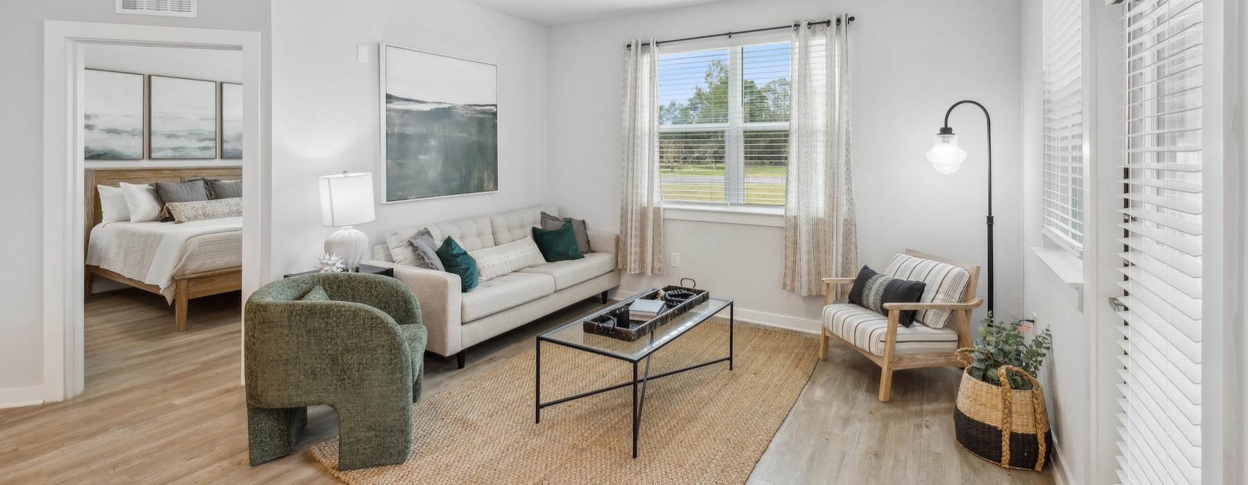 a living room with a wood floor, a couch and chairs
