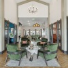 a clubroom with open glass doors, chairs and tables