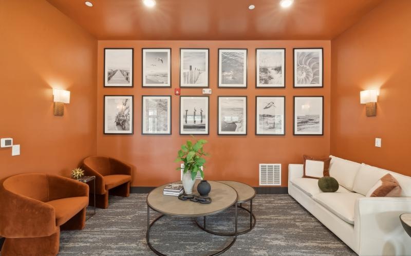 a clubroom with a couch, a coffee table and chairs
